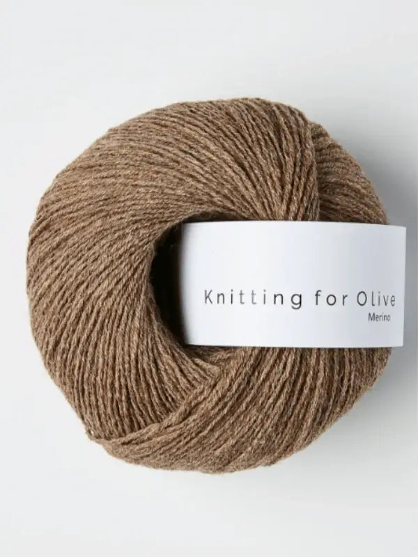 A ball of Knitting for Olive Merino yarn with a white label lies on a plain background. This light brown, Öko-Tex certified merino wool ensures quality and safety for your knitting projects.