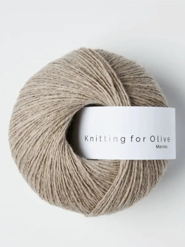 A ball of light brown Knitting for Olive Merino yarn with a white label sits on a plain white background.