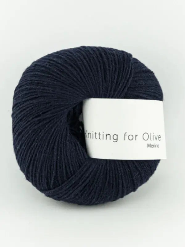 A ball of dark navy blue Knitting for Olive Merino yarn, Öko-Tex certified, sits on a white background.
