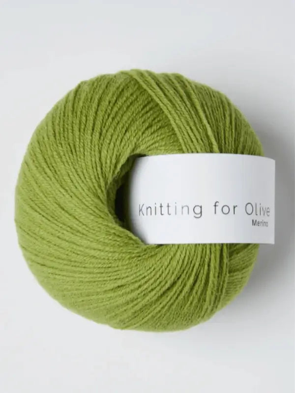 A light green ball of Knitting for Olive Merino yarn with a white label rests on a plain background. Öko-Tex certified, it's ideal for safe and eco-friendly crafting.