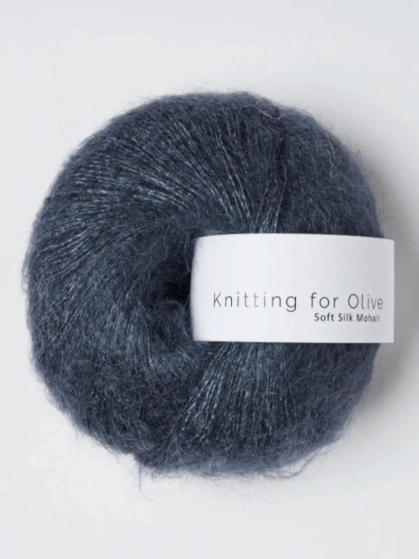 A ball of Knitting for Olive Soft Silk Mohair in dark gray rests on a white background, highlighting the luxurious look of this mohair blend yarn.