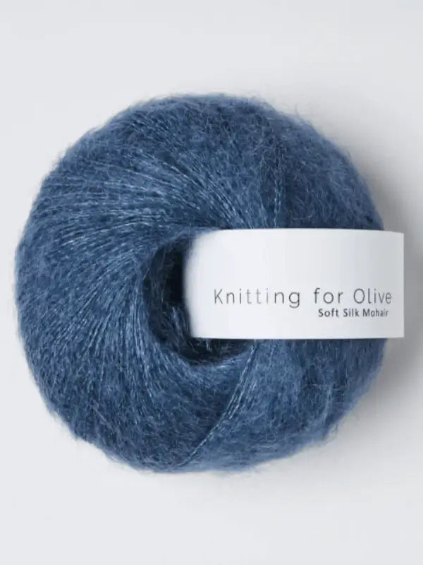 A skein of Knitting for Olive Soft Silk Mohair yarn, crafted from luxurious Kid mohair and certified to the Responsible Mohair Standard, rests against a simple light backdrop—an exquisite silkki lanka choice for your upcoming creation.