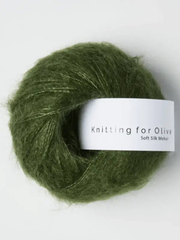 A ball of olive green Knitting for Olive Soft Silk Mohair yarn with a white band around the center, displayed against a plain background. This premium blend of kid mohair and silk meets the Responsible Mohair Standard, guaranteeing ethical sourcing and remarkable softness for your knitting projects.