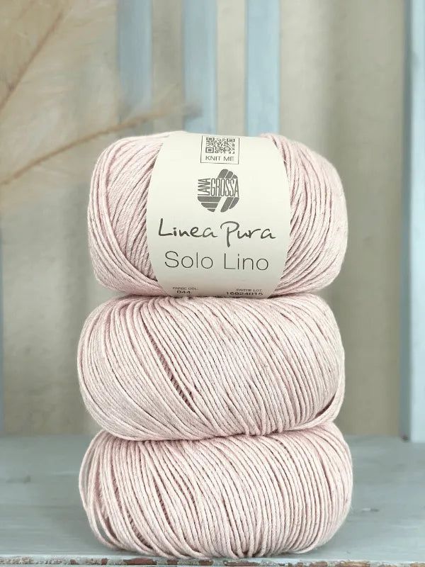 Three balls of pale pink Lana Grossa Solo Lino yarn are stacked vertically, with the label "Linea Pura Solo Lino" visible on the top ball against a soft, light background.