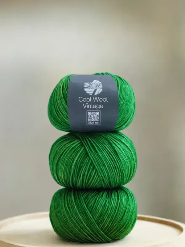 Three stacked skeins of vibrant Lana Grossa Cool wool vintage merino yarn.