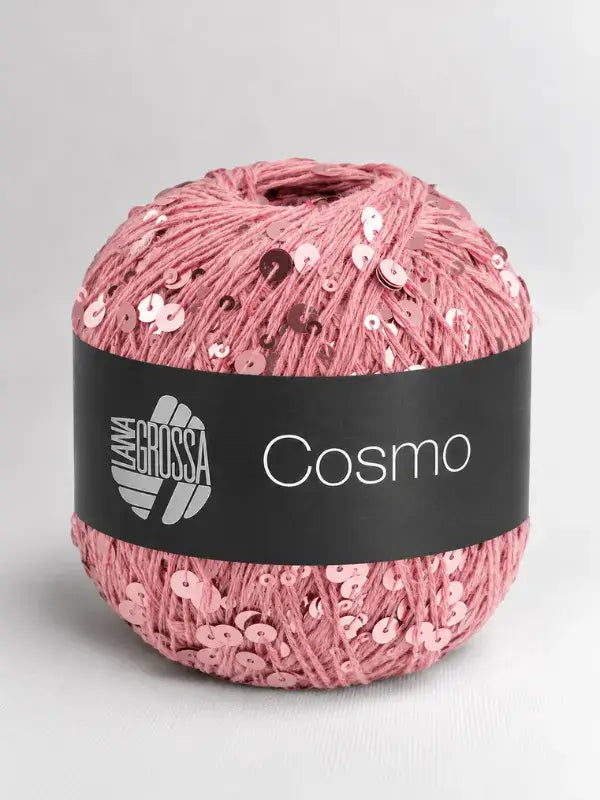 A ball of dusty pink Lana Grossa Cosmo yarn embellished with matching sequins and wrapped in a black paper label.