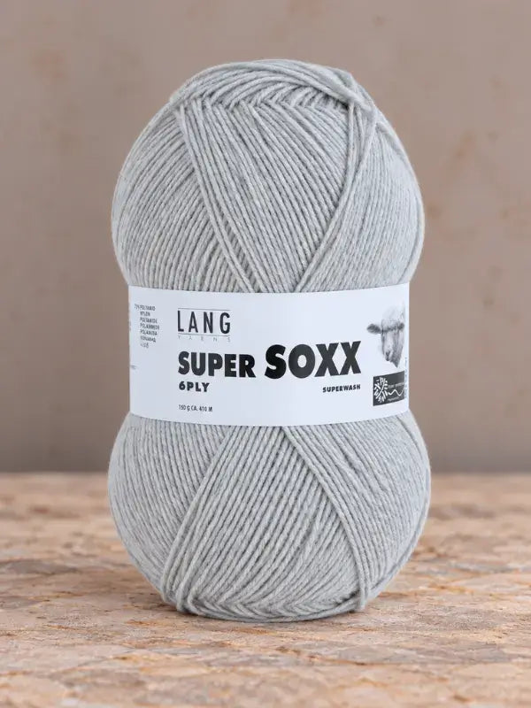 A ball of light gray Lang Yarns Super Soxx 6 ply – kestävä sukkalanka villasta yarn with a product label featuring a sheep icon.