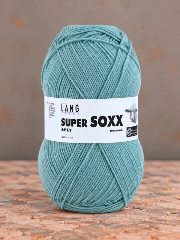 A ball of Lang Yarns Super Soxx 6 ply – kestävä sukkalanka villasta teal yarn with a label.