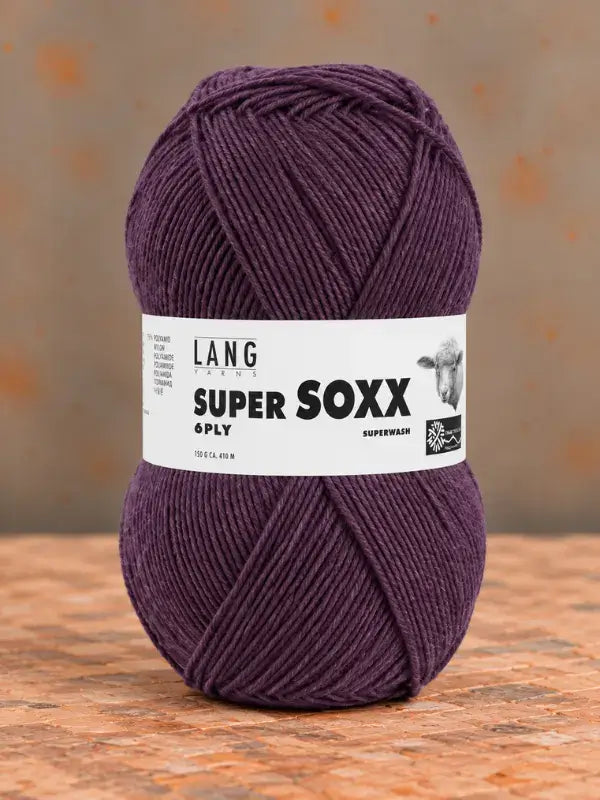 A skein of deep purple Lang Yarns Super Soxx 6 ply – kestävä sukkalanka villasta yarn with a white product label wrapped around the center.