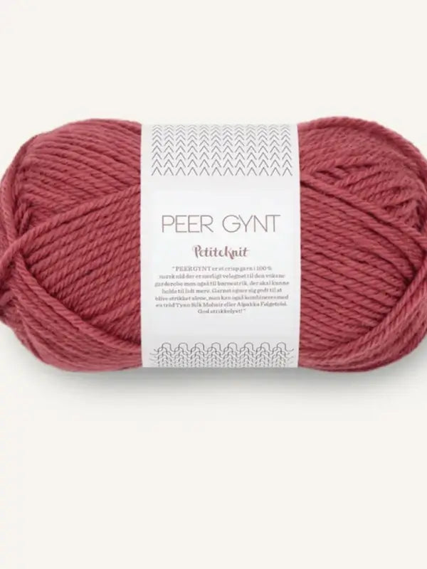 A skein of dusty rose colored Sandnes Garn Peer Gynt yarn, wrapped with a white and gray label showing the brand and product details—perfect for your next Petiteknit Amy Sweater project.