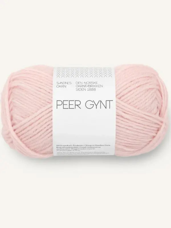 A skein of light pink Sandnes Garn Peer Gynt yarn with a white label featuring the Norwegian brand’s name and product information. Made from high-quality Norwegian wool, this villalanka is perfect for your knitting projects.