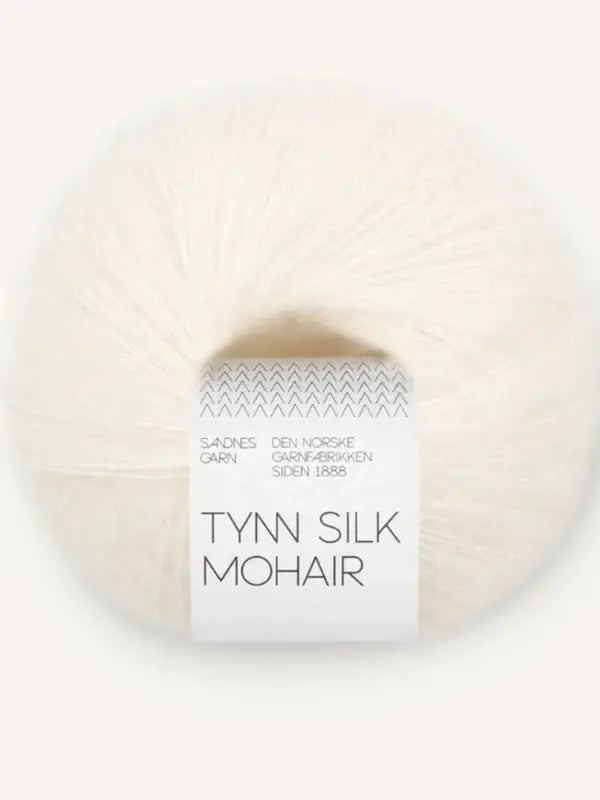 A ball of Sandnes Garn Tynn Silk Mohair in white, a luxurious silk mohair yarn, featuring a label that displays “Tynn Silk Mohair” with additional Norwegian text above the product name, set against a neutral background.
