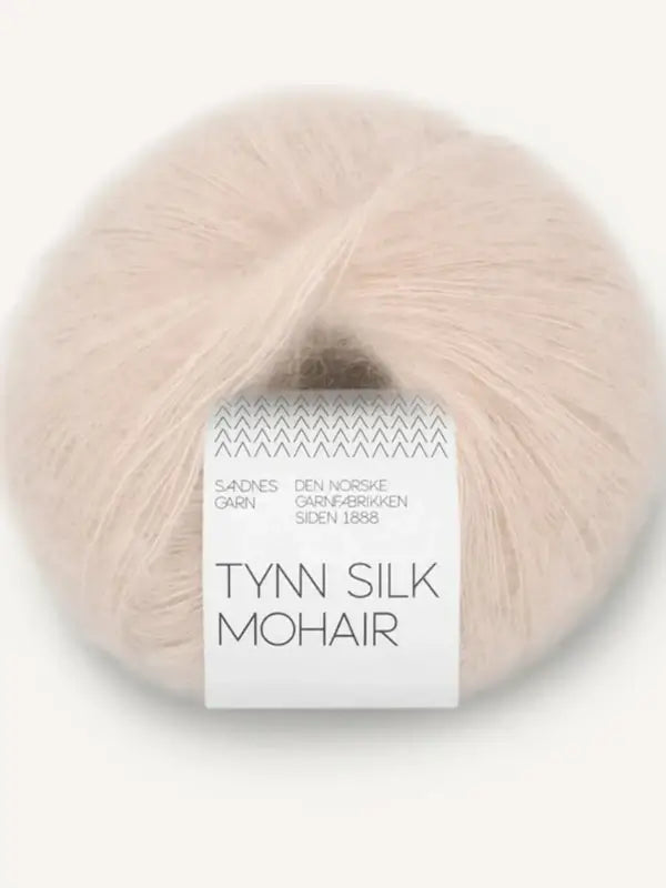A ball of pale cream-colored silk mohair yarn labeled Sandnes Garn Tynn Silk Mohair, wrapped with a white band that displays the brand name and product details.
