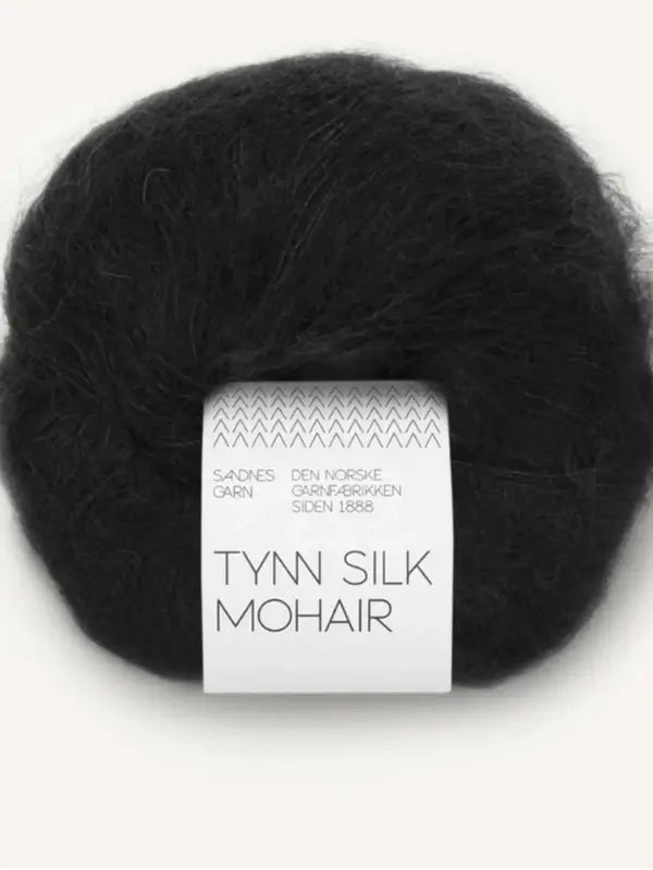 A skein of Sandnes Garn Tynn Silk Mohair in black, also known as silkki-mohairlanka, featuring a white label with Norwegian text and simple graphic patterns.