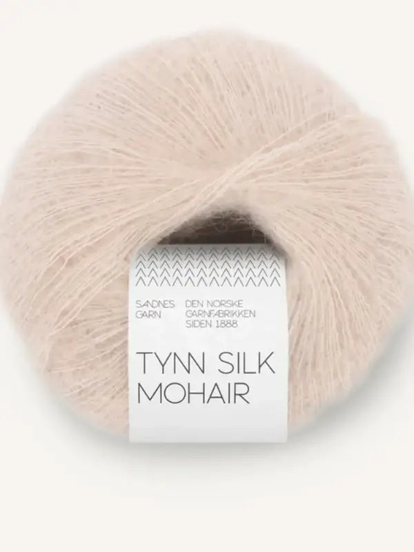 A soft and fluffy ball of light beige yarn labeled Sandnes Garn Tynn Silk Mohair, wrapped with a white paper band that displays the product information.