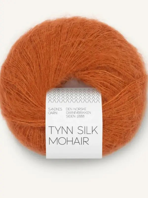 A ball of thin, rust-colored Sandnes Garn Tynn Silk Mohair yarn with white packaging and gray text.