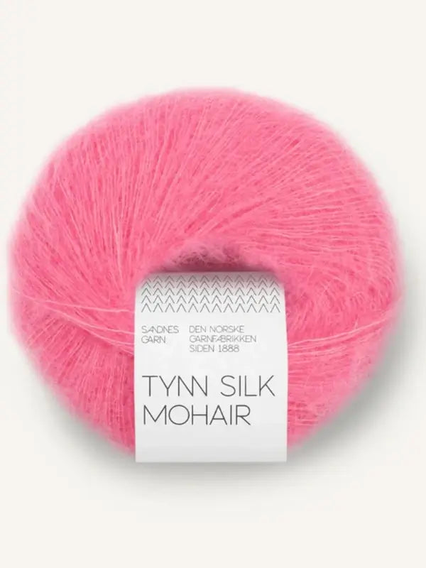 A ball of Sandnes Garn Tynn Silk Mohair—luxurious, bright pink silk-mohair yarn—comes with a white and gray paper band wrapped around its center.
