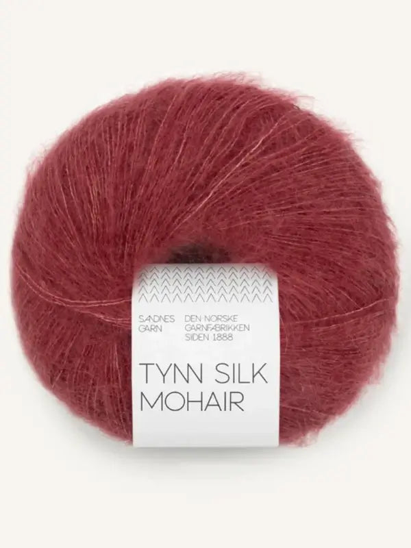 A ball of Sandnes Garn Tynn Silk Mohair yarn in a reddish-brown shade, featuring a white label with the brand name and text in Norwegian.