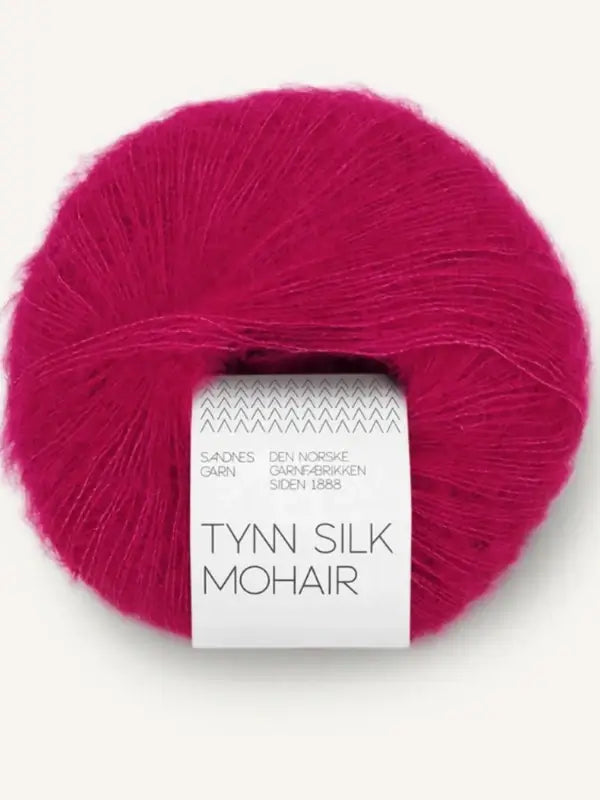 A luxurious ball of Sandnes Garn Tynn Silk Mohhair in bright pink, wrapped with a white paper band—this silk-mohair yarn is perfect for delicate and elegant projects.