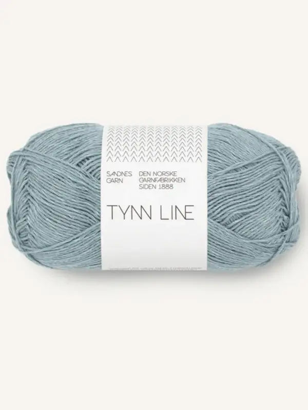 A skein of Sandnes Garn Tynn Line in light blue, a fingering weight yarn with white packaging, displaying text and a simple geometric pattern at the top.