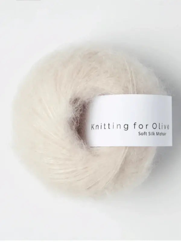 An off-white ball of Knitting for Olive Soft Silk Mohair yarn with a white label is displayed against a plain background.